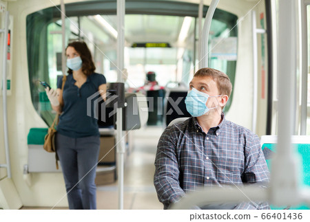 Passenger in disposable mask in city streetcar Passenger in disposable mask in city streetcar 66401436