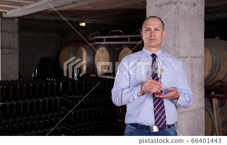 Winemaker offering white sparkling wine for tasting Winemaker offering white sparkling wine for tasting 66401443