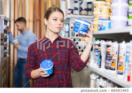 Woman is choosing with paint for repair Woman is choosing with paint for repair 66401465