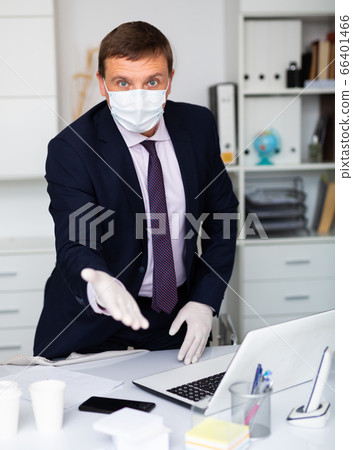 Businessman in mask and gloves welcoming to office 66401466
