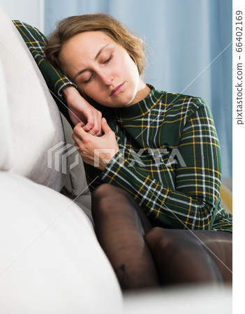 Portrait of sorrowful woman sitting at home Portrait of sorrowful woman sitting at home 66402169