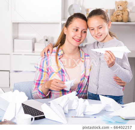 Woman and girl making airplanes of pape Woman and girl making airplanes of pape 66402257