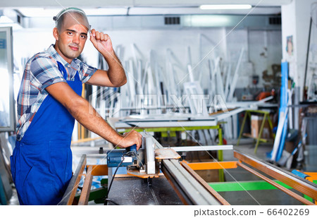 Confident workman ready to working on circular saw 66402269