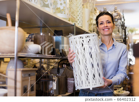 Woman holding item for her home in decor furnishings shop 66402312