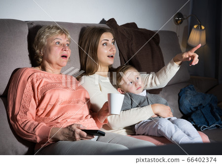 Two women and toddler are enjoying of watch film in evening Two women and toddler are enjoying of watch film in evening 66402374