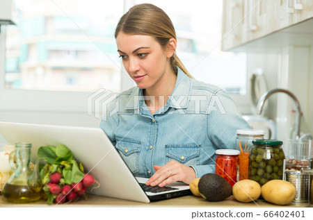 Girl with laptop at home kitchen Girl with laptop at home kitchen 66402401