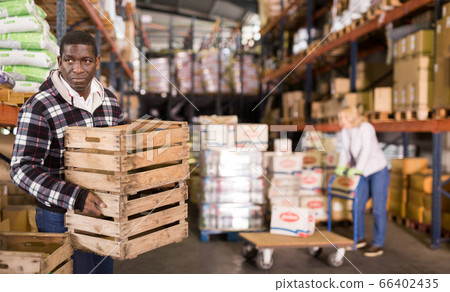 Warehouse worker stacking wooden boxes 66402435