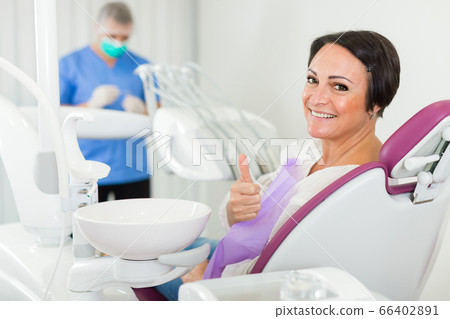 patient female thumbs up in medical room 66402891