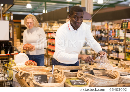 Man choosing bulk products in store 66403092