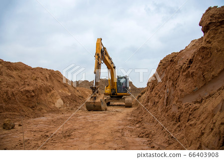 Excavator digs a large trench for pipe laying Excavator digs a large trench for pipe laying 66403908