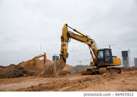 Excavator at building under construction. Excavator at building under construction. 66403922