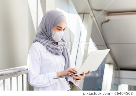 Asian muslim businesswoman wearing medical mask for prevent dust and infection virus. Asian muslim businesswoman wearing medical mask for prevent dust and infection virus. 66404508