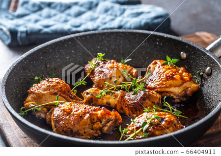 Tasty chicken legs roasted in ceramic pan with 66404911