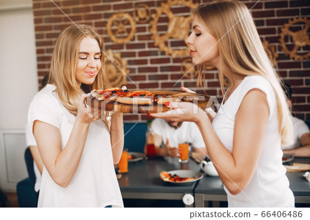 Cute friends in a cafe eatting a pizza 66406486