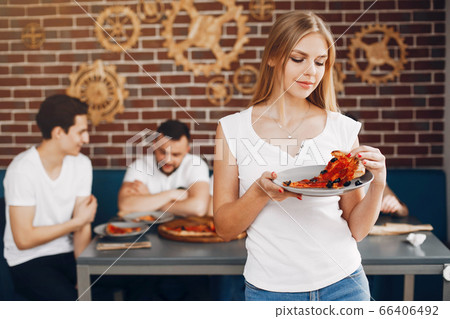 Cute friends in a cafe eatting a pizza 66406492