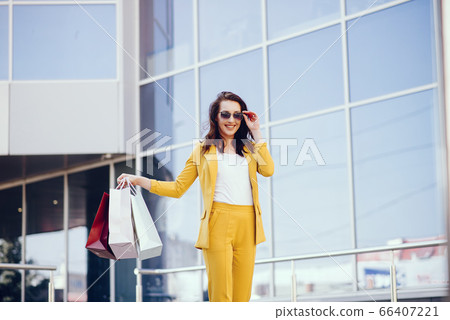 Cute girl with shopping bag in a city Cute girl with shopping bag in a city 66407221