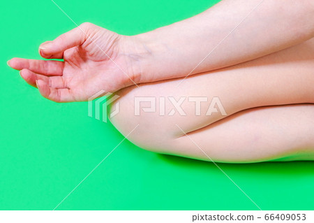 Woman sitting in yoga pose on green Woman sitting in yoga pose on green 66409053
