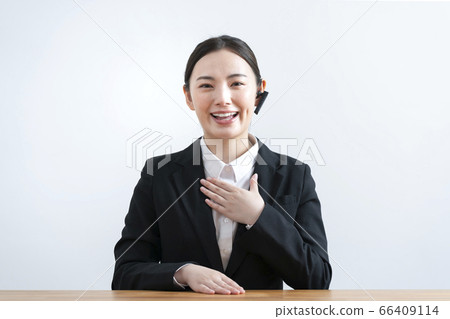 A young woman in a suit wearing a headset and talking from the camera's perspective A young woman in a suit wearing a headset and talking from the camera's perspective 66409114