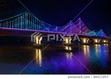 The scenery of the Tapi river bridge with the colorful light decoration at dusk in Surat Thani. The scenery of the Tapi river bridge with the colorful light decoration at dusk in Surat Thani. 66411957