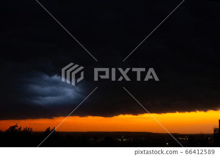 Black thunderclouds at sunset. Bright orange 66412589