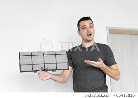 The guy cleans the filter of the home air 66412820