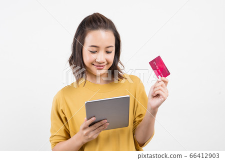 young woman using tablet and credit card 66412903