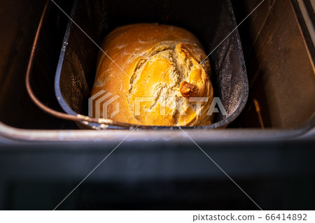 Baked bread loaf in bread-maker just out of. Top view 66414892