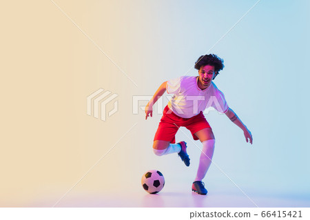 Football or soccer player on gradient background in neon light - motion, action, activity concept 66415421