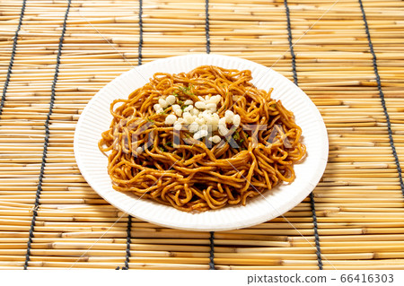 調味在紙碟的油煎的麵條。炒麵的形象,如夏季節日攤位。 調味在紙碟的油煎的麵條。炒麵的形象,如夏季節日攤位。 66416303