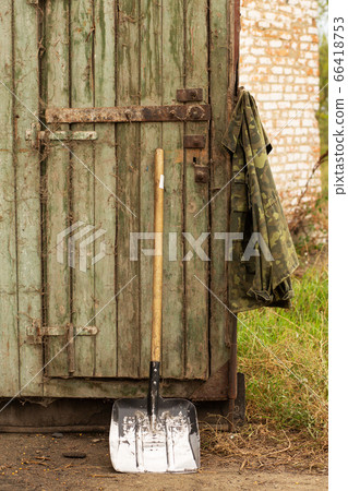 Shovel at the gates of the hangar. Harvest season. Shovel at the gates of the hangar. Harvest season. 66418753