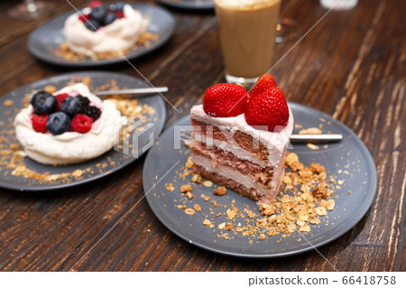 Sweet cakes with summer berries on a wooden table. Sweet cakes with summer berries on a wooden table. 66418758