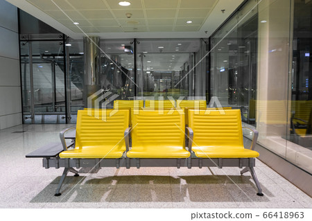 Rows of yellow benches in a waiting area at the 66418963