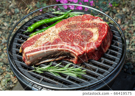 raw cowboy steak on grilled 66419575