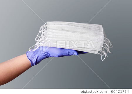Medical fase masks on a hand in glove 66421754