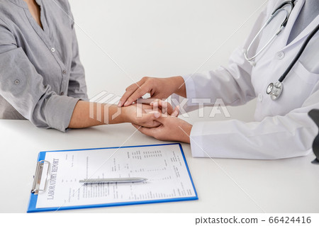 The doctor examines the patient's pulse by hand and records the results 66424416