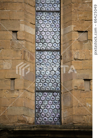 Beautiful stained-glass window of old building. Exterior of gothic style architecture. 66425049