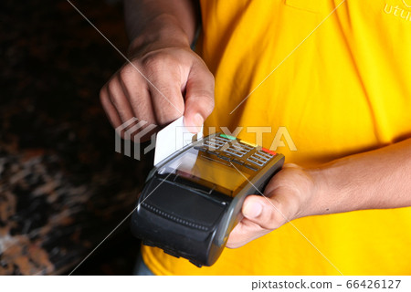 Payment terminal charging from a card, Close up 66426127