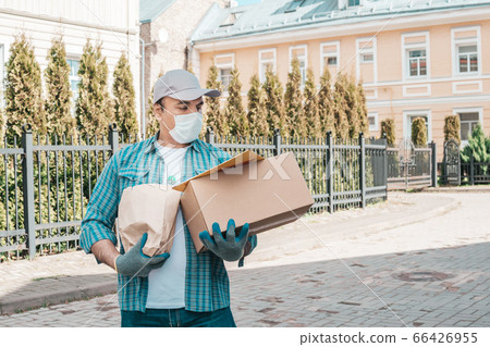 Courier in protective mask and medical gloves 66426955