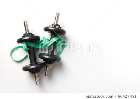 Sport black dumbbells and measuring tape on grey Sport black dumbbells and measuring tape on grey 66427451