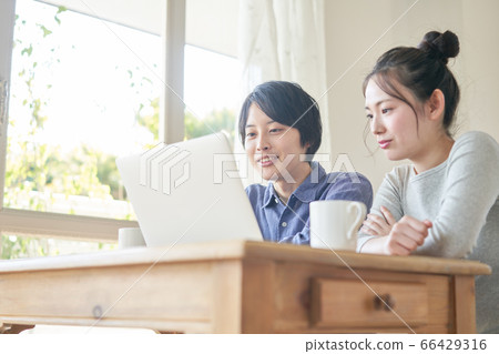 看著一台個人計算機的年輕夫婦 66429316