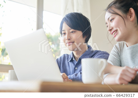 看著一台個人計算機的年輕夫婦 66429317