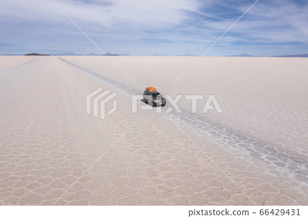 Aerial morning of a 4x4 on Uyuni salar. South of Bolivia. 66429431