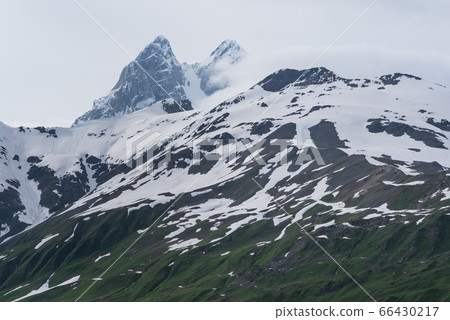 Snowy mountain massif with two peaks behind that are tops of Ushba Mountain. On the trek from Mestia to Mazeri (Becho). Georgia. The Caucasus 66430217
