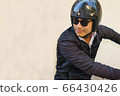 Asian motorcyclist is riding his motorcycle. Asian motorcyclist is riding his motorcycle. 66430426