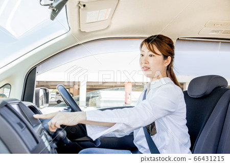 一個年輕的女人,操作汽車導航系統 一個年輕的女人,操作汽車導航系統 66431215