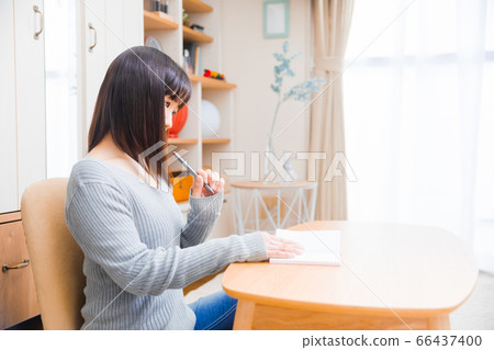A woman thinking about copy space to fill in a notebook A woman thinking about copy space to fill in a notebook 66437400