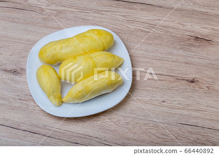Fresh durian fruit placed on a white plate.  66440892