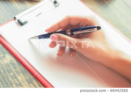 Woman's hand writing on a blank planner at cafe. Woman's hand writing on a blank planner at cafe. 66442988