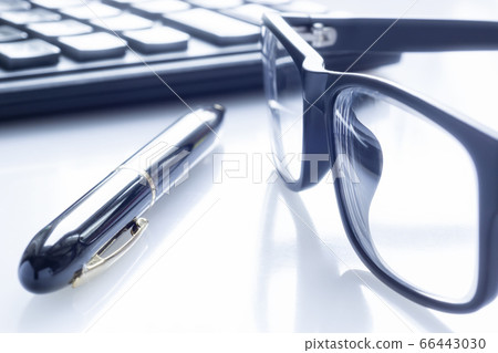 Stylish black business glasses, pen and calculator on white Stylish black business glasses, pen and calculator on white 66443030