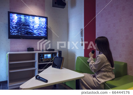 一個女人在卡拉OK箱唱歌的圖像材料 66444576